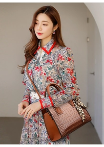 Détail du sac à main crocodile avec foulard léopard porté sur une robe à fleurs