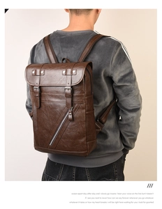 Dettaglio zaino vintage in pelle PU marrone con fibbie e tasca laterale con zip diagonale