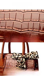 Détail du sac marron avec texture crocodile et foulard en soie à imprimé léopard