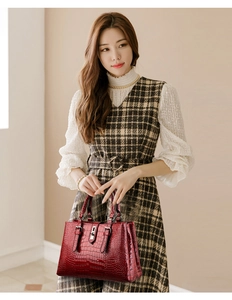 Détail d'un sac à main rouge foncé motif crocodile avec fermoir argenté chic