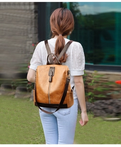 Detail of vintage brown PU leather backpack with buckle flap and woven shoulder straps