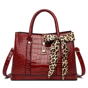 Deep red crocodile embossed tote bag with gold lock and leopard print scarf handle wrap