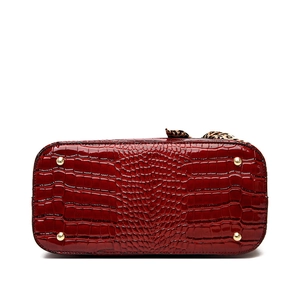 Bottom view of burgundy crocodile pattern tote bag with four gold protective metal feet