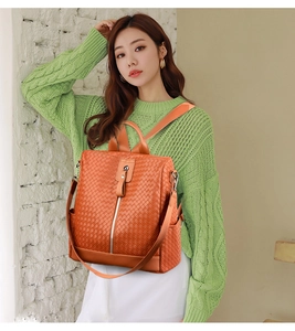 Detail of orange woven leather backpack with silver zippers and convertible straps