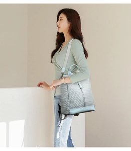 Detail view of light blue woven texture backpack with adjustable grey straps
