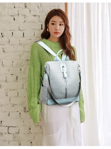 Close-up of light blue woven texture and silver zipper detail on multifunctional backpack