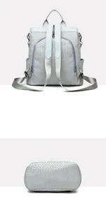 Detail view of light blue woven texture backpack showing rear anti-theft zipper and flat base