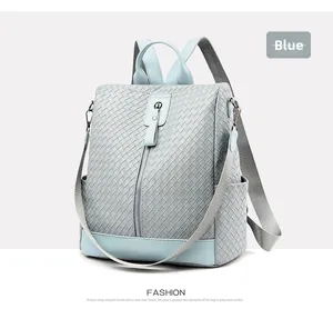 Detail of light blue woven texture and leather stitching on a fashion backpack
