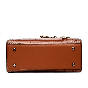 Vue de dessous du sac à main marron effet crocodile avec quatre pieds de protection