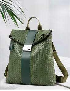 Details der gewebten Kunstleder-Textur und Metallschnalle am grünen Mode-Rucksack