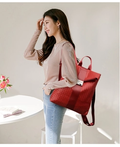 Détail d'un sac à dos rouge tressé avec boucle métallique et lanière verticale