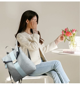 Détail d'un sac à dos tissé avec boucle en métal et design bicolore élégant en gros plan