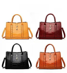 Detailed grid view of embossed crocodile leather texture on tote bags in four colors