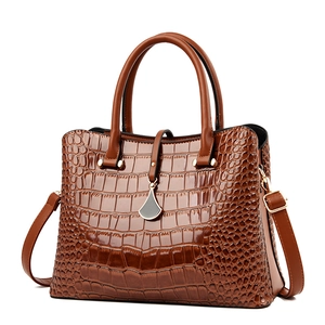 Classic caramel brown crocodile embossed handbag with metal charm and long strap