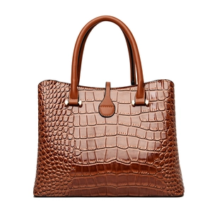 Brown crocodile embossed tote bag with twin handles and gold hardware on white background