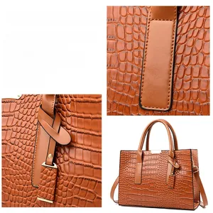 Detail of brown crocodile pattern tote bag showing stitching and removable strap