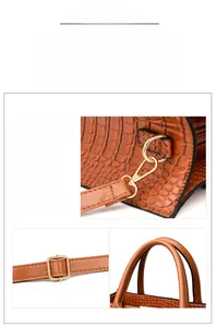 Detail of durable gold zippers and adjustable strap hooks on brown crocodile pattern bag