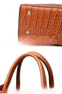 Detail view of the orange-brown crocodile embossed handbag with protective bottom rivets