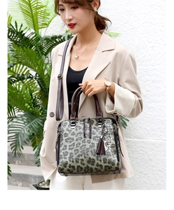 Detail der Handtasche mit Leopardenmuster, Krokoprägung, Quastenanhänger und Gurt