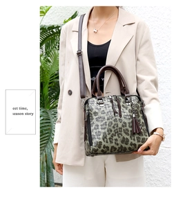 Detailansicht der grünen Handtasche mit Krokodilprägung, Lederquasten und Silberbeschlag