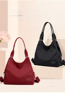 Detail of red and black nylon tote bags with detachable straps and logo patch