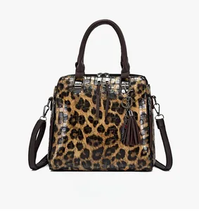 Detail der Damenhandtasche mit Leopardenmuster, Krokoprägung und braunen Griffen