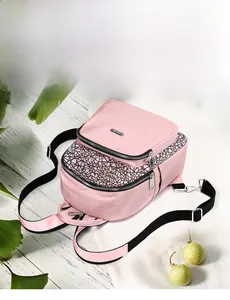 Detailed view of pink Oxford backpack with black geometric lines and metallic zippers