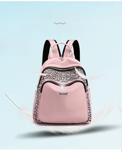 Detail view of light pink water-resistant nylon backpack with black geometric patterns