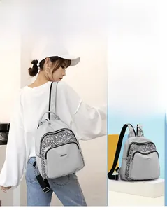 Detail of light grey nylon backpack showing black and white crackle pattern side pockets