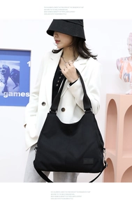 Close-up of durable black nylon tote bag with reinforced handles and brand patch