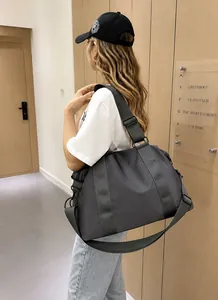 Dettaglio della borsa da viaggio grande in nylon grigio scuro con manici e tracolla regolabile