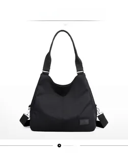 Front detail of a black nylon tote bag featuring high-density waterproof fabric and durable straps
