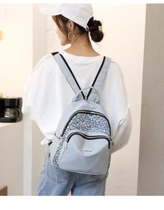 Detail view of the light blue Oxford backpack with reflective geometric patterns and zippers