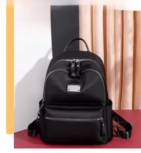 Detail view of the black oxford fabric backpack showing multi-pockets and silver zippers