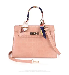 Pink Kelly style handbag with crocodile embossing and a colorful silk scarf handle wrap
