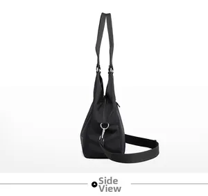 Side view of black nylon tote bag showing triangular silhouette and adjustable strap