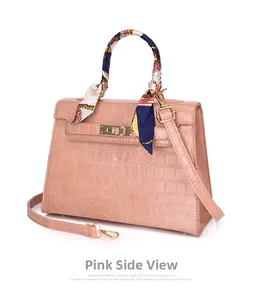 Detailed side view of pink crocodile pattern handbag with decorative handle scarf