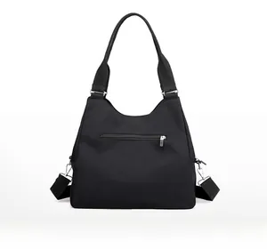 Rear view of black nylon shoulder bag featuring a silver zippered security pocket
