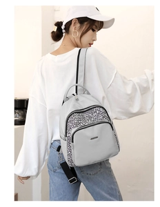 Detail of light grey oxford backpack featuring a geometric pattern front pocket and side pocket