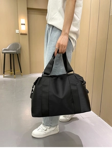 Dettaglio della borsa capiente in nylon nero con manici rinforzati per viaggio o sport