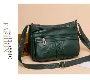 Dettaglio borsa a tracolla verde scuro in pelle martellata con trama intrecciata e zip multiple