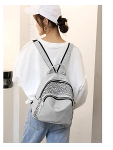Detail view of a light grey nylon backpack with geometric crackle pattern and zipper