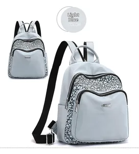 Detail view of light blue oxford backpack with geometric patterns and metal logo