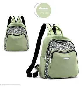Detail of light green oxford backpack with reflective geometric patterns and metal logo