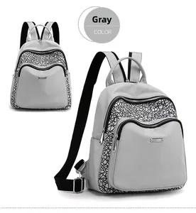 Detail of grey oxford backpack featuring reflective geometric patterns and metal logo