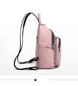 Side view of pink Oxford fabric backpack with honeycomb pattern and side pocket