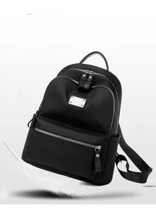 Detail showing high-quality black nylon material and silver zippers on a lightweight backpack