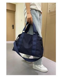 Dettaglio borsa da viaggio in nylon blu con cinghie rinforzate e tracolla rimovibile