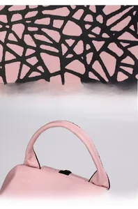 Detail of pink geometric backpack with reflective fabric texture and soft top handle
