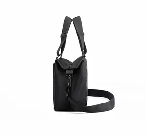 Vista laterale della borsa a tracolla in nylon nero con tasca a zip e tracolla regolabile